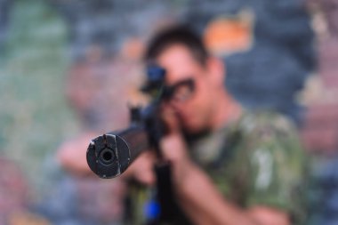 Aktif savaş sırasında Ukraynalı bir askerin nişan aldığı bir tüfek namlusuna yakından bakın. Sığ alan derinliği silahın ve gerilim anının altını çizer. Ukrayna 'da savaş kavramı, askeri çatışma, şehir savaşı, ulusal savunma ve silahlı kuvvetler