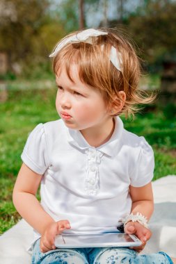 Küçük kız tablete bir oyun oynamak. Bir Tablet kullanan kız. 