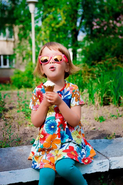 Niña en gafas de sol rosadas sentada y comiendo helado —  Fotos de Stock