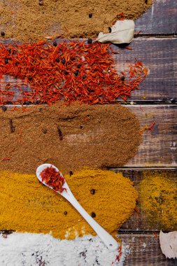Çeşitli baharatlar seçimi safran, zerdeçal, köri. ahşap arka plan üzerinde farklı kuru baharat.