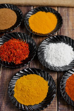 Çeşitli baharatlar seçimi safran, zerdeçal, köri. ahşap arka plan üzerinde farklı kuru baharat.