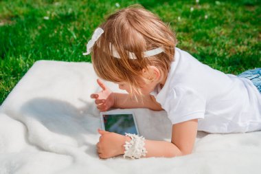  Tablet üzerinde küçük bir kız. Bir Tablet kullanan kız. 