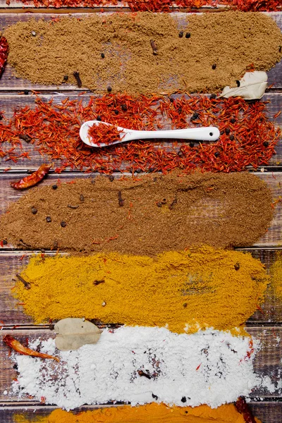 Varias especias selección Azafrán, cúrcuma, curry. diferentes especias secas sobre un fondo de madera . — Foto de Stock