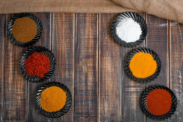 Diverse specerijen selectie saffraan, kurkuma, kerrie. verschillende droge kruiden op een houten achtergrond. — Stockfoto