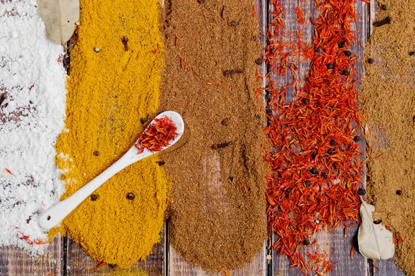 Berbagai pilihan rempah-rempah Saffron, kari kunyit, kari. rempah-rempah kering yang berbeda pada latar belakang kayu . — Stok Foto