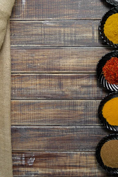 Diverse specerijen selectie saffraan, kurkuma, kerrie. verschillende droge kruiden op een houten achtergrond. — Stockfoto