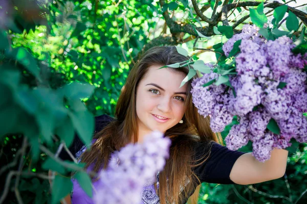 Портрет Красивой, длинноволосой, темноволосой девушки в фиолетовом платье на цветущих деревьях — стоковое фото