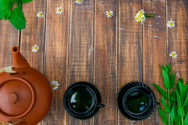 İki siyah çay bardak yakınındaki kahverengi çaydanlık