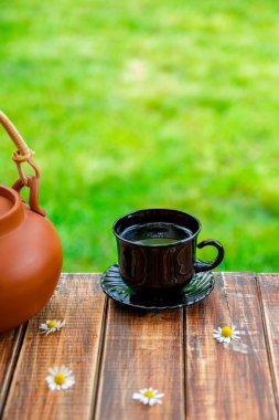 Kahverengi demlik çay fincan sade yakınındaki papatya ile ahşap