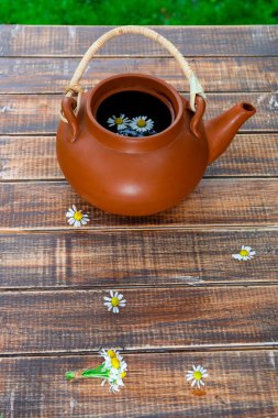 Açık kahverengi demlik çay ve çiçek papatya