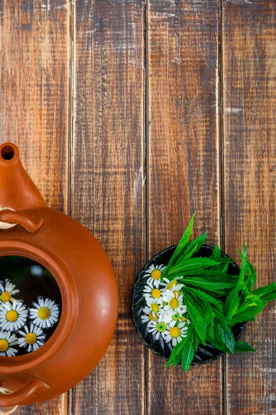 Open brown teapot with flower of chamomile — Stock Photo, Image