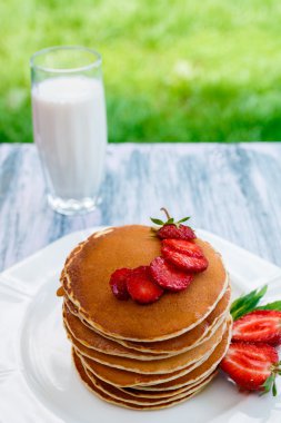 Pancakes with fresh strawberry with milk