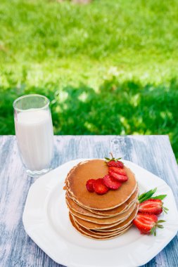 Pancakes with fresh strawberry with milk