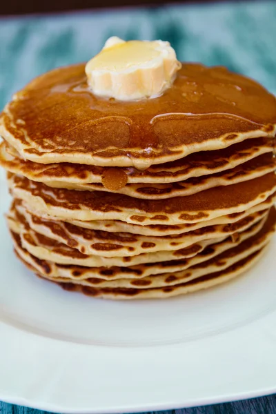 Pancakes with butter and honey on white plate — Stockfoto