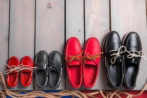 Ahşap arka plan üzerinde aile tekne Ayakkabı