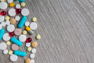 çok renkli ilaç ve gri ahşap arka plan üzerinde yukarıdan hapları. Uzay kopyalayın. Üstten Görünüm, çerçeve. Ağrı kesiciler, tablet, jenerik, ilaç.