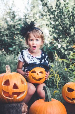 Halloween. Elinde jack-o-fener ile siyah giyinmiş çocuk, hile veya tedavi. Küçük kız balkabağı, dışarıda. Wow. Tonlu fotoğraf.