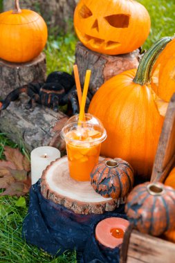 Arka planda balkabağı süslemesi olan Cadılar Bayramı kokteyli. Parti için yumruk. Jack-o-Fener. 