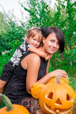 Halloween. Kızı bahçede jack-o-fener yakınında anne sarılma. Parti için dekorasyon. Mutlu aile.