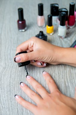 Siyah oje el ile manikür arka plan üzerinde uygulanmakta. Güzel süreci. Yakın çekim.