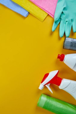 Fotokopi alanı olan sarı masa üzerindeki ev temizleme ürünleri, farklı yüzeyler için temizlik seti, Deterjan servis konsepti, Top view.