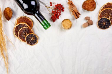 Kış mevsimlik sıcak şarap için bir şişe malzeme ve bir şişe kırmızı şarap.