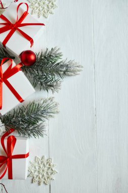 Noel hediyesi kutusu, köknar ağacı dalları, beyaz ahşap arka planda kırmızı süslemeler, Noel, kış, yeni yıl konsepti, düz döşeme, üst manzara, kopyalama alanı