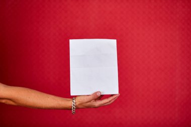 Kapalı kurye elinde alışveriş poşeti, teslimat servisi, stüdyo çekimi kırmızı arkaplanda izole edilmiş, kopyalama alanı.