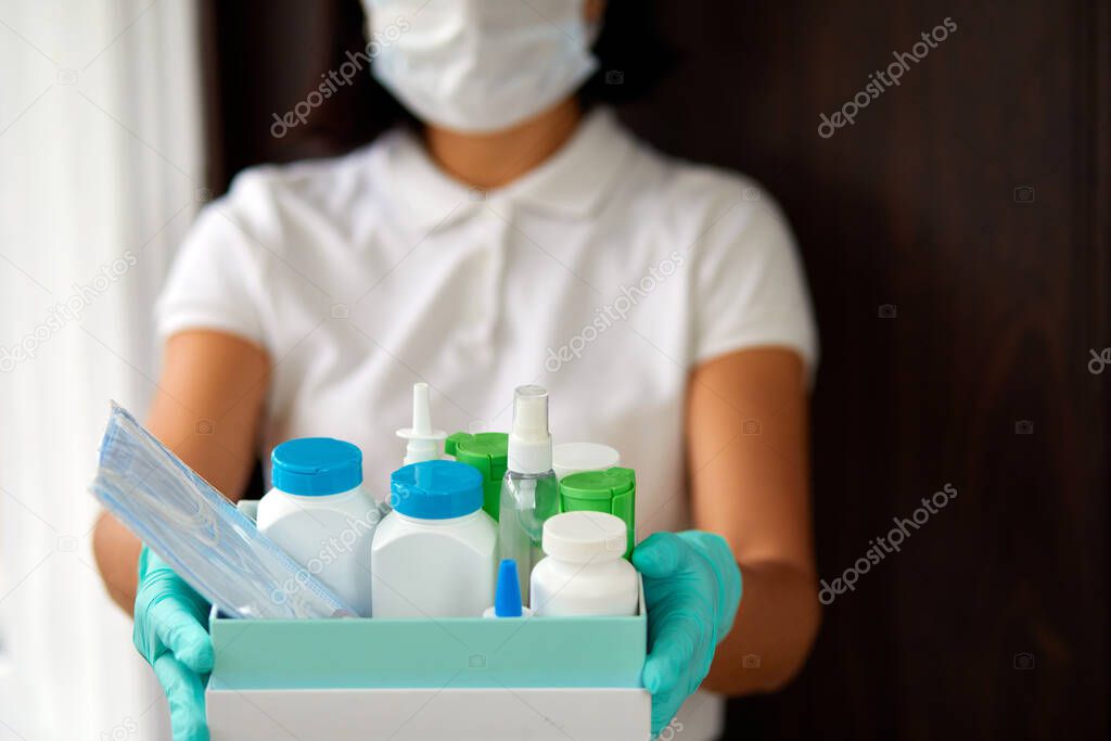 Medicine woman courier in mask and gloves with medical pills purchases during the prevention of coronovirus, Safety home and quarantine concept, Volunteer with Donation goods.