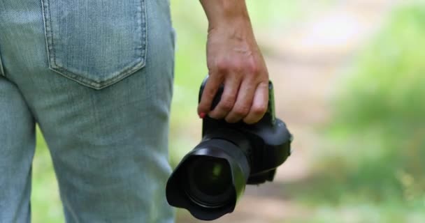 Mujer fotógrafa con una cámara fotográfica en la mano caminar al aire libre, — Vídeos de Stock