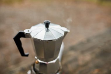 Metal gayzer kahve makinesiyle, gaz ocağında adım adım kamp kahvesi yapma süreci.