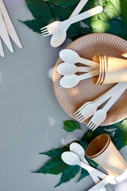 Çevre sanatı kağıdı ve ahşap sofra takımı, sıfır atık, plastiksiz ve çevre dostu yaşam, kağıt bardaklar, tabaklar ve ahşap kesici geri dönüşüm veya çevre dostu konsept.