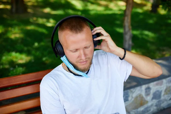 Mann Hört Musik Mit Kopfhörer Trägt Gesichtsschutzmaske Freien Park Lebensstil — Stockfoto