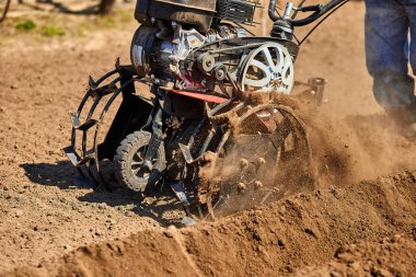 Bahçıvan, toprak toprağını dümen traktörü, rototiller, cutivator, misina makinesi ile işlet. Baharda ekin ekmeye hazır ol. Modern tarım, teknoloji tarımı.