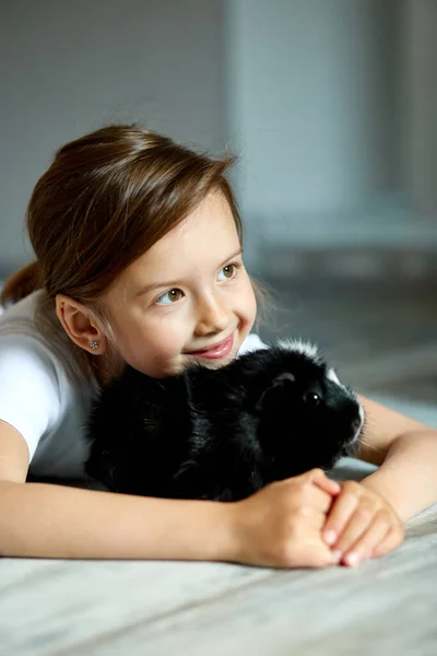 Portret Uśmiechniętej Dziewczynki Przytulającej Czarną Świnkę Morską Urocze Dziecko Zabawą — Zdjęcie stockowe