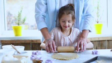 Baba küçük kızına kurabiye nasıl rulo yapılır, mutfakta nasıl pişirilir, evde aile yemeği nasıl pişirilir gösteriyor..