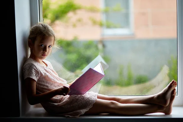 Linda Niña Leyendo Libro Casa Alféizar Ventana Niño Estudiando Casa —  Fotos de Stock