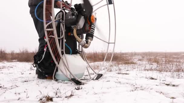 Close up of man hands starts to work a propeller, motor, engine of the paramotor paraglider — Stock Video