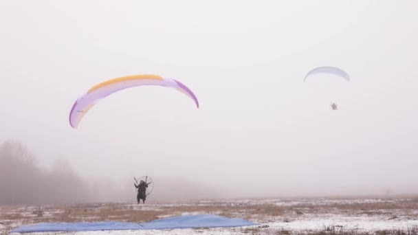 Landing met paraglider paramotor gliding in mist — Stockvideo