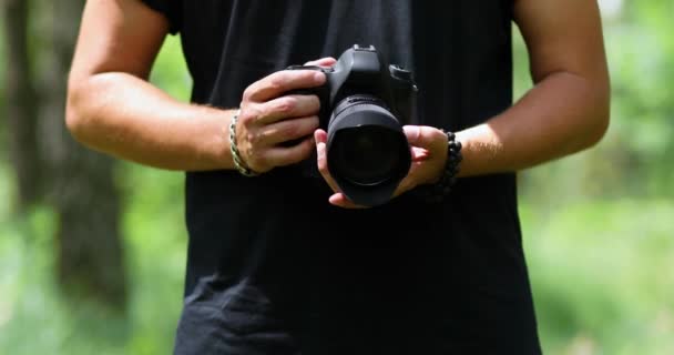 Man fotograaf met een foto camera configureert outdoor — Stockvideo