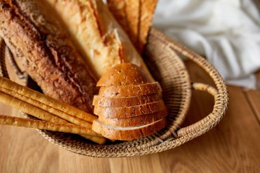 Ahşap bir yüzeyde çeşitli ekmek türlerinin üst görüntüsü. Ev yapımı ekmek, küçük fırın, doğal tarım ürünleri, yerel gıda, yerli üretim kavramı. Sağlıklı ve lezzetli organik yiyecekler..