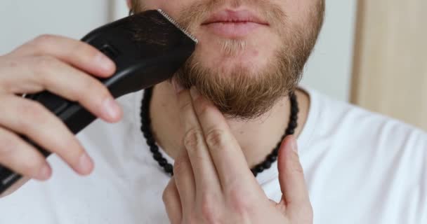 英俊的男人 身穿白色T恤衫 修剪胡子 在家里亲自修剪胡子 隔离期间的自我照顾 呆在家里 — 图库视频影像