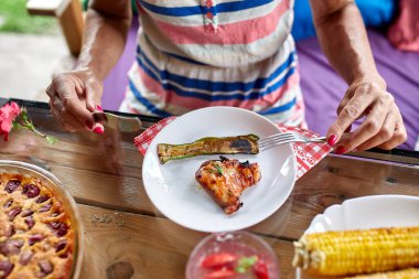 Yemek yiyen kadın bıçak ve çatalla yemek yiyor. Yemek masası, aperatifler.