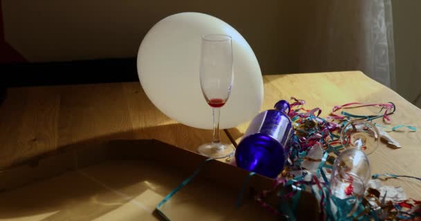 パーティーのお祝いの後の朝にピザボックス 空の青いボトル ワイングラス パーティーの装飾が施された厄介な木製のテーブル パーティーの混乱の後 お祝いの残り物 — ストック動画