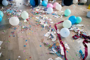 En üst kat, parti sonrası boş mavi şişeler, şarap kadehleri ve parti dekorasyonları, dağınık oturma odası iç mekanları, parti kaosundan sonra, doğum günü kutlamalarından sonra.