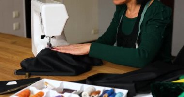 Adım adım, 50 yaşındaki yaşlı kadın dikiş makinesine kıyafet dikiyor atölye, tekstil endüstrisi, hobi, çalışma alanı ile çalışan olgun bir terzi. Oluşturma süreci DIY, Terzinin İş Yeri.