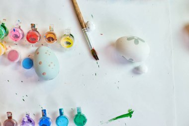 Beyaz arka planda fırçalı, boyalı ve dekoratif elementli yumurta paketleri. Uzayı kopyala, Mutlu Paskalyalar, DIY, düz yat.
