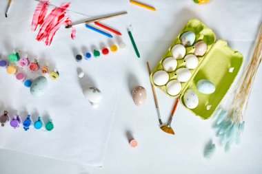 Beyaz arka planda fırçalı, boyalı ve dekoratif elementli yumurta paketleri. Uzayı kopyala, Mutlu Paskalyalar, DIY, düz yat.