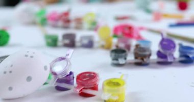 Evde fırça yumurtasıyla resim çizen mutlu küçük kız. Çocuk Paskalya için hazırlanıyor, eğleniyor ve ziyafeti kutluyor. Mutlu Paskalyalar, DIY