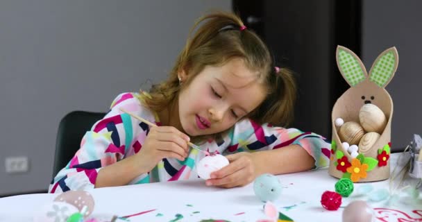 Ευτυχισμένο κοριτσάκι ζωγραφική, σχέδιο με αυγά βούρτσα στο σπίτι. — Αρχείο Βίντεο